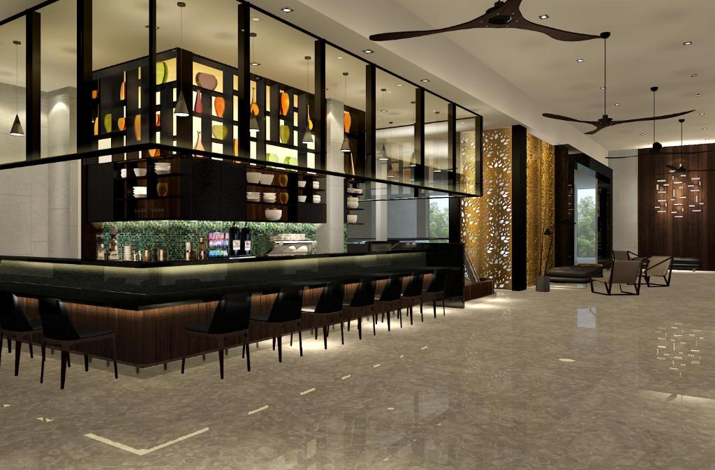 Luxurious hotel lobby with a long bar, black stools, glass shelves, and decorative screens in warm lighting.
