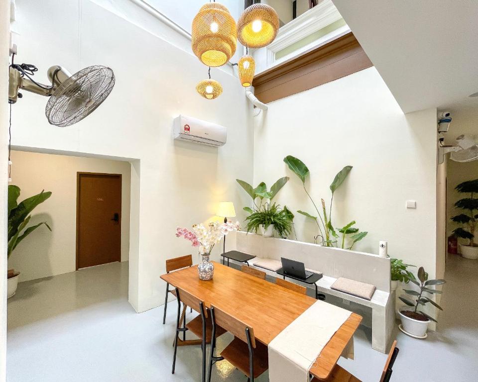 Bright dining area with wooden table and chairs, potted plants, and hanging wicker pendant lights.