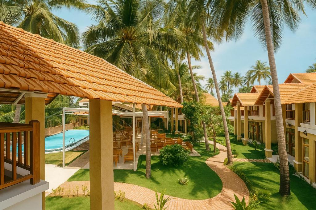 Resort courtyard with orange-tiled roofs, tall palm trees, and a rectangular pool bordered by lounge chairs.
