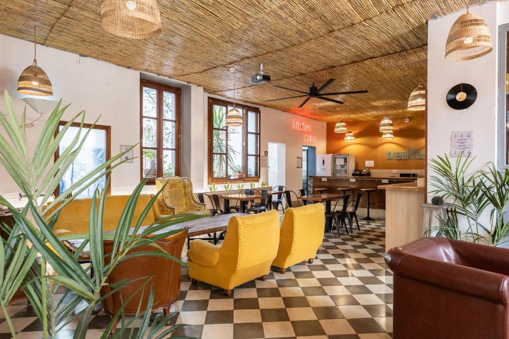 Cozy cafe interior with checkered floor, yellow upholstered chairs, and hanging wicker lamps