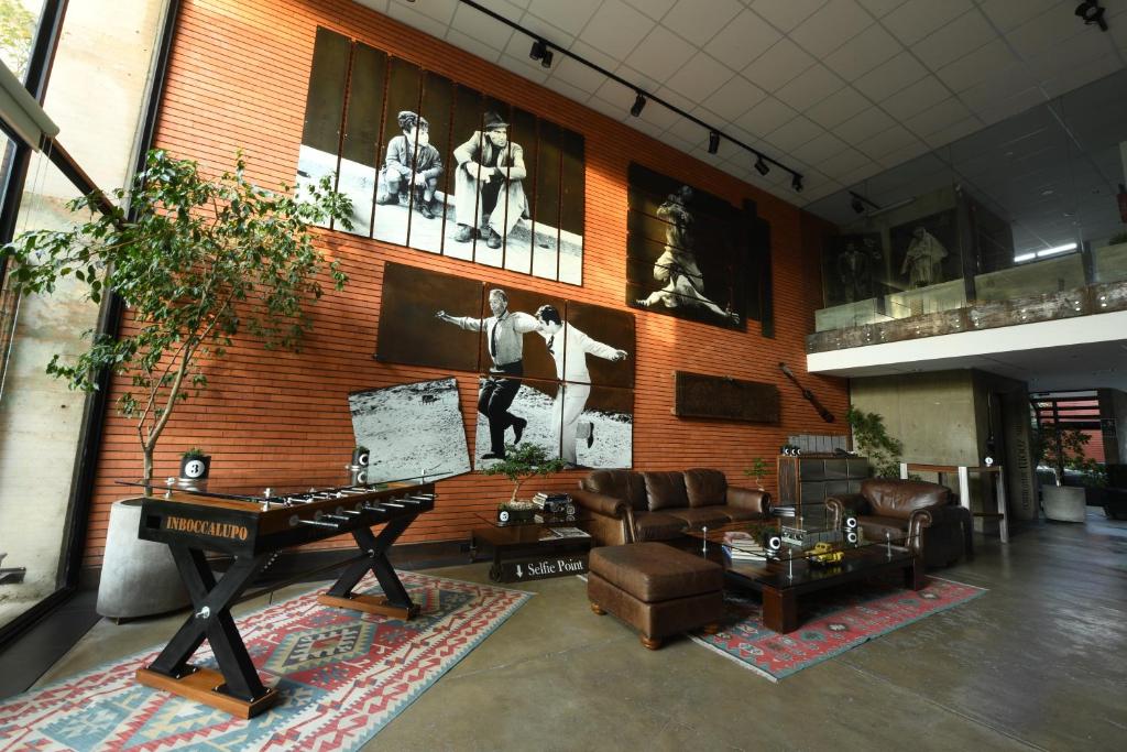 Industrial loft-style living area with a brick wall, large black-and-white photo panels, and a leather sofa set.