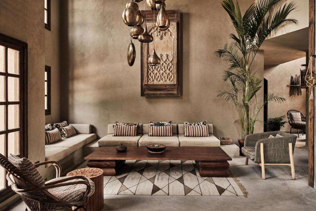 Living room with a beige sectional, striped cushions, and a large wooden coffee table on a geometric rug, bathed in natural light from windows.