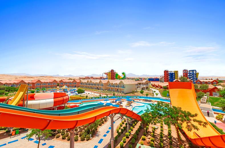 Colorful water slides winding through a sunny outdoor water park with pools and loungers nearby.