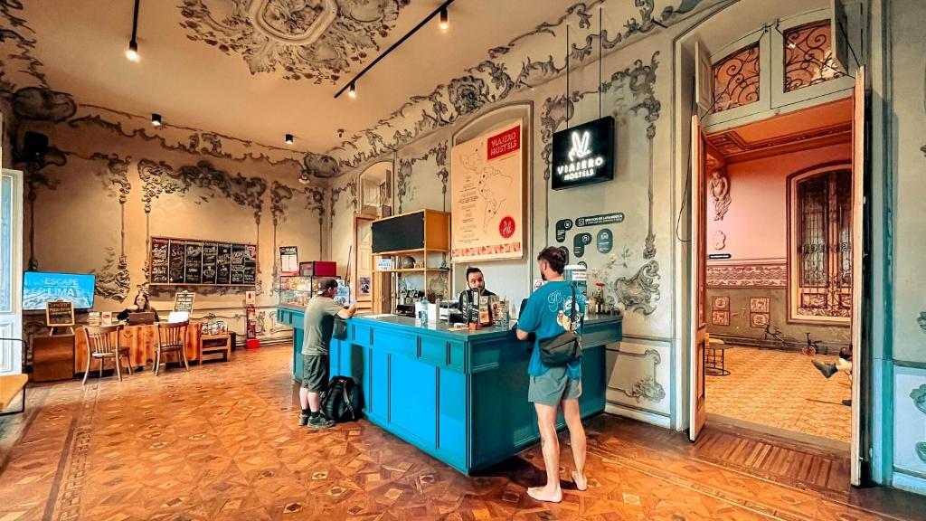 Blue service counter in a historic, ornately painted cafe; two customers order from staff.