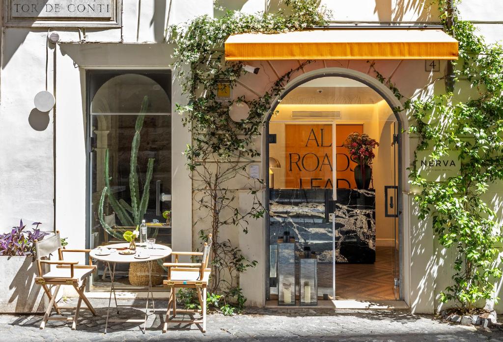 Cafe storefront with orange awning and outdoor table seating on a cobblestone street, ivy climbing the entrance.