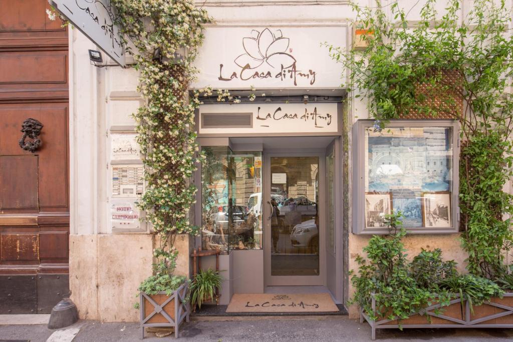 Facade of La Casa di Amy boutique with glass door and climbing white flowers and green vines