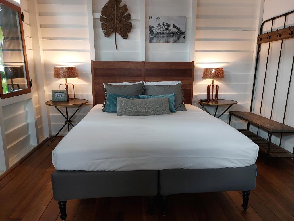 Bedroom with a wooden headboard bed, white linens, gray and teal pillows, and matching bedside lamps。