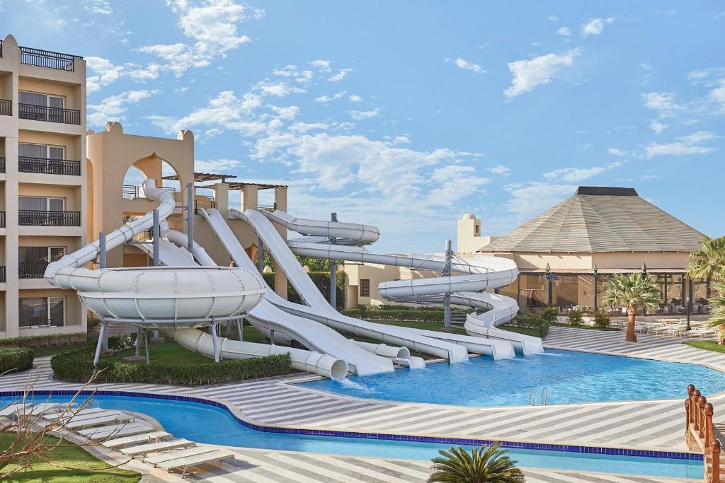 Resort pool with multiple white twisting waterslides and blue pool water.
