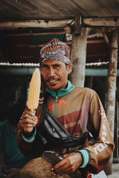 Man met maiskolf op strand in Lombok
