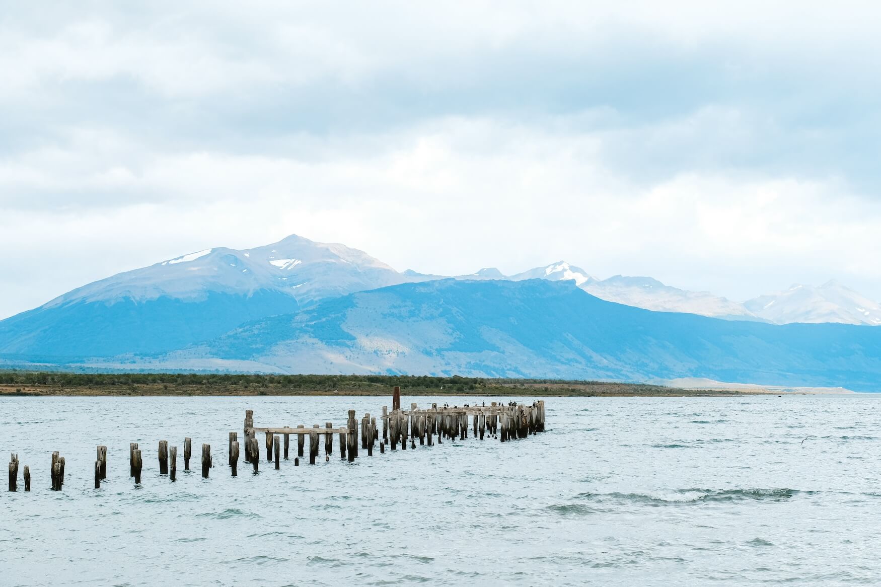 Langs de kade lopen met uitzicht op bergen Puerto Natales