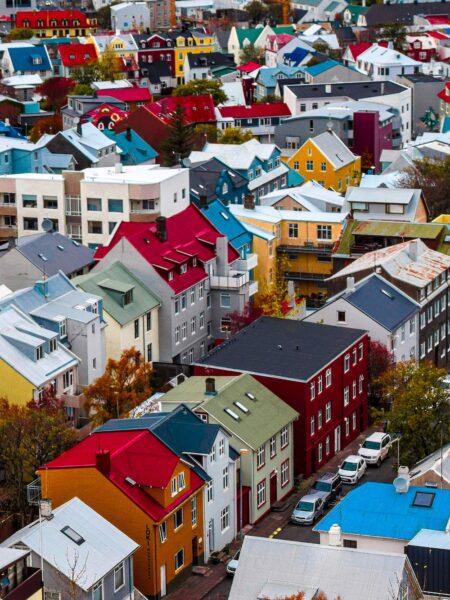 Colorful hillside neighborhood with tightly packed houses and vibrant red, blue, and yellow roofs.