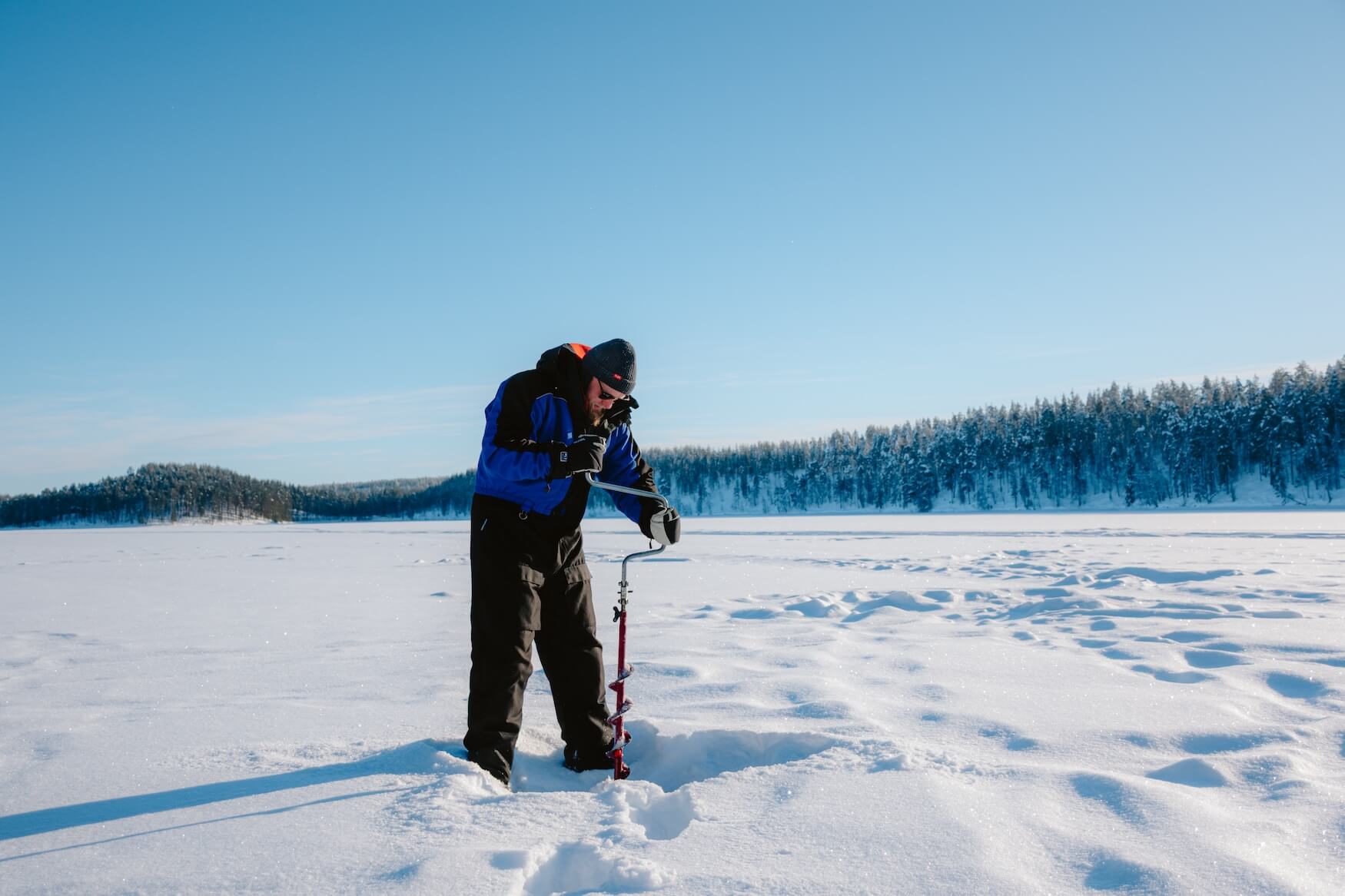 ijswak boren om te vissen in Kuusamo