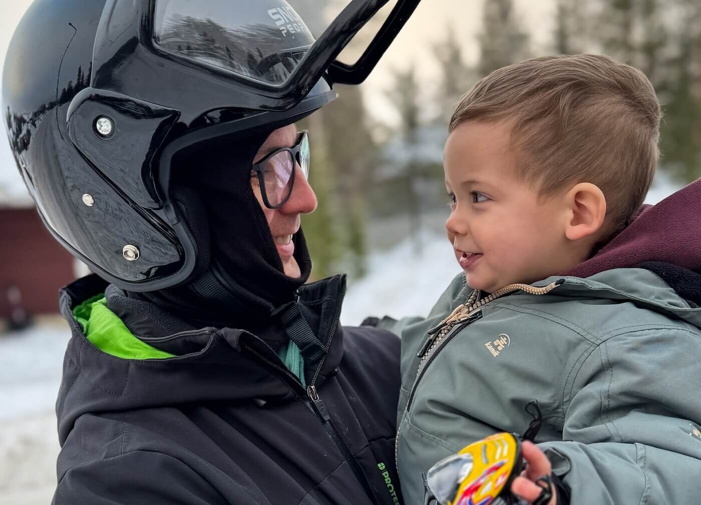 vader en zoon met speelgoed sneeuwscooter